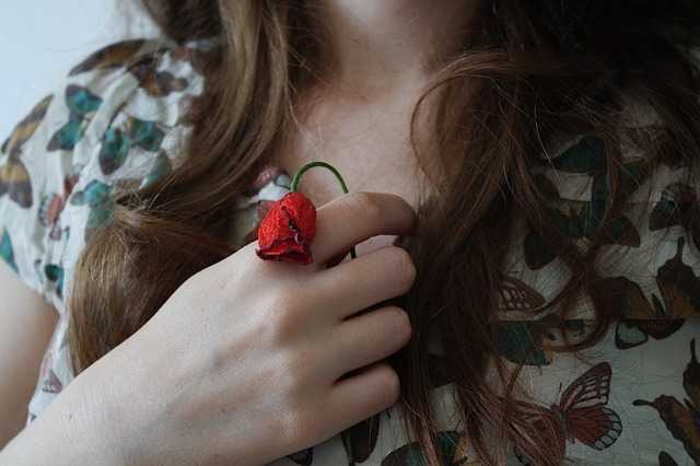 赤い花を持っている女性