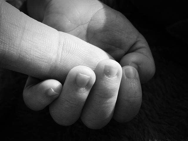 赤ちゃんの手が親の人差し指を掴む白黒写真